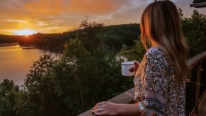 MFI H2h Cottage Co woman drinking coffee and watching sunset at one of the best luxury Haluburton cottage rentals
